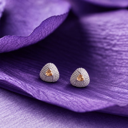 Close-up ear view wearing a triangular champagne stone stud with sparkling clear zircon detailing and a polished silver-tone finish.
