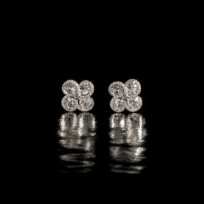 Quadra Halo Stud Earrings with four faceted clear stones, clear zircon borders and silver-tone setting displayed on a glossy black reflective surface.