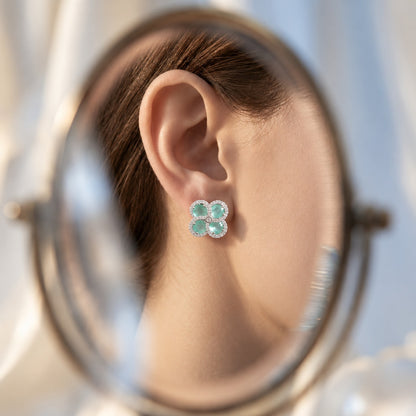 Close-up ear view wearing Quadra Halo Stud Earrings, showing the four-petal  mint aqua stone design and sparkling clear zircon detailing