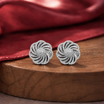 Silver-tone circular statement stud earrings with swirling openwork design and clear zircon stone detailing.
