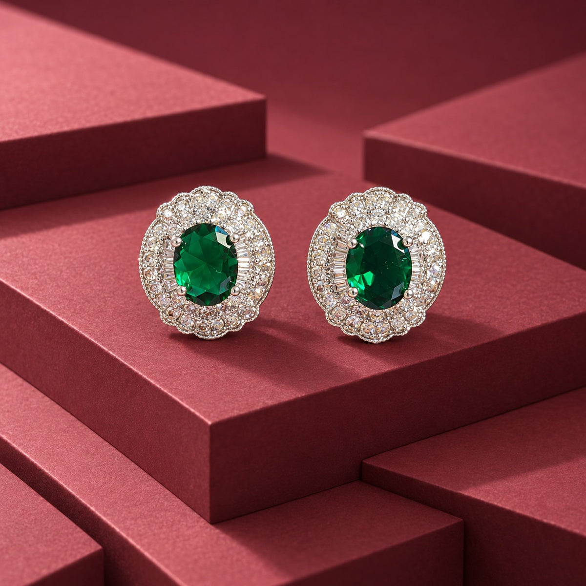 Verdanza Oval statement stud earrings with a faceted oval emerald green centre stone and detailed clear zircon surround in a polished silver-tone setting