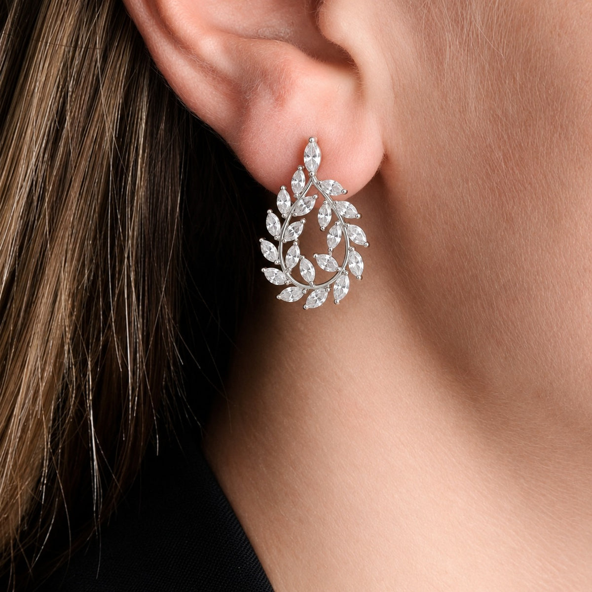 Close-up of Silver Laurel Drop Earring worn on the ear, showing clear marquise zircon stones forming a sweeping leafy teardrop design.