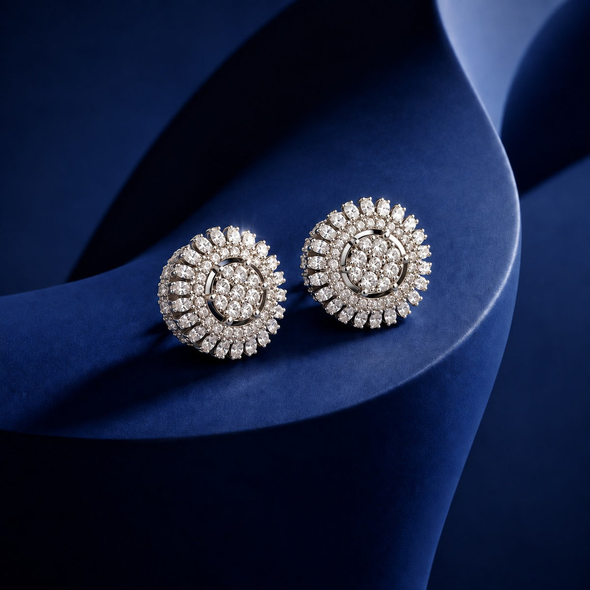Celestial Wheel Stud Earrings featuring a circular silver-tone design with clustered clear zircon centres and radiating marquise-cut zircon detailing