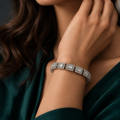 The Framed Link Bracelet worn on a woman's wrist, featuring individually framed rectangular clear stones in a polished silver-tone setting.