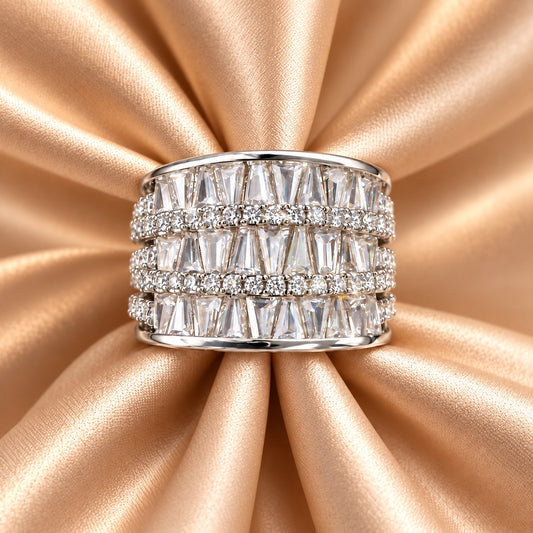 Front close-up of the S925 sterling silver Tierline Ring on champagne satin, showing its wide multi-row design with tapered and round clear zircon.