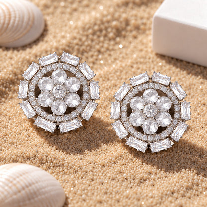 Clear white floral stud earrings with six faceted clear petals, round zircon centre and an outer circle of rectangular clear stones.