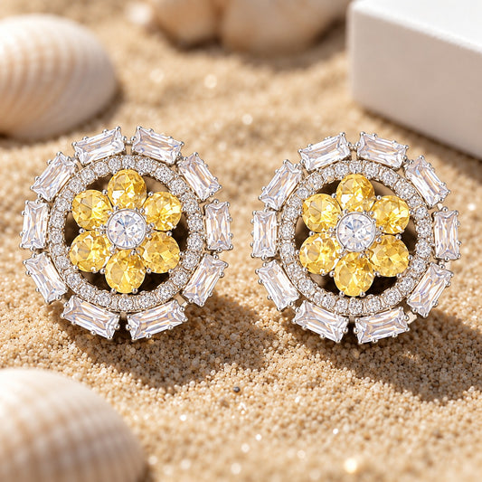 Close-up of sun yellow Petal Orbit Stud Earrings with faceted yellow floral petals, clear zircon centre and rectangular clear stones in a silver-tone frame