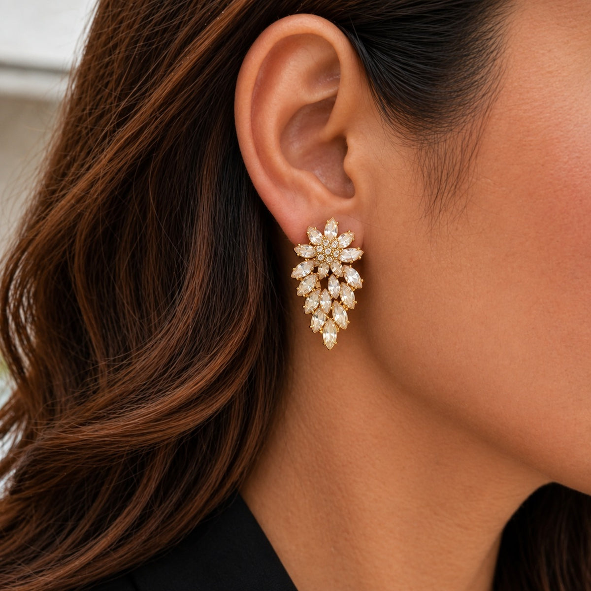 Woman wearing a Gilded Laurel Drop Earring with clear marquise stones forming a layered floral cluster that tapers elegantly below the earlobe