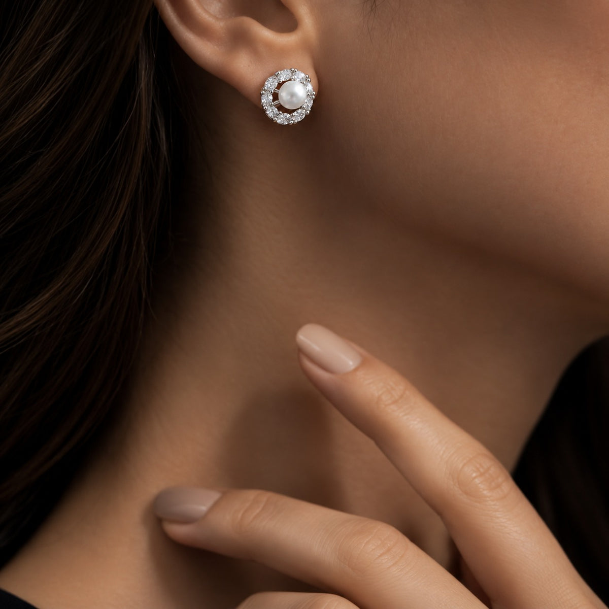 Woman wearing a Pearl Circuit Stud Earring with a white pearl centre framed by a circular arrangement of clear stones in silver-tone metal