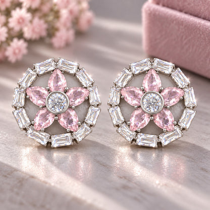Petal Circuit Stud Earrings featuring five  blush pink pear-cut coloured gemstone petals, a round clear zircon centre and a circular border of clear baguette stones in silver-tone metal.”