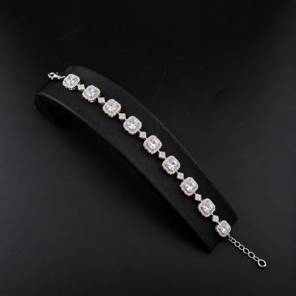 Silver-tone Regal Grid Bracelet featuring square-cut gemstones surrounded by clear zircon borders and connected with small diamond-shaped zircon links, available in ruby red, emerald green and clear zircon.