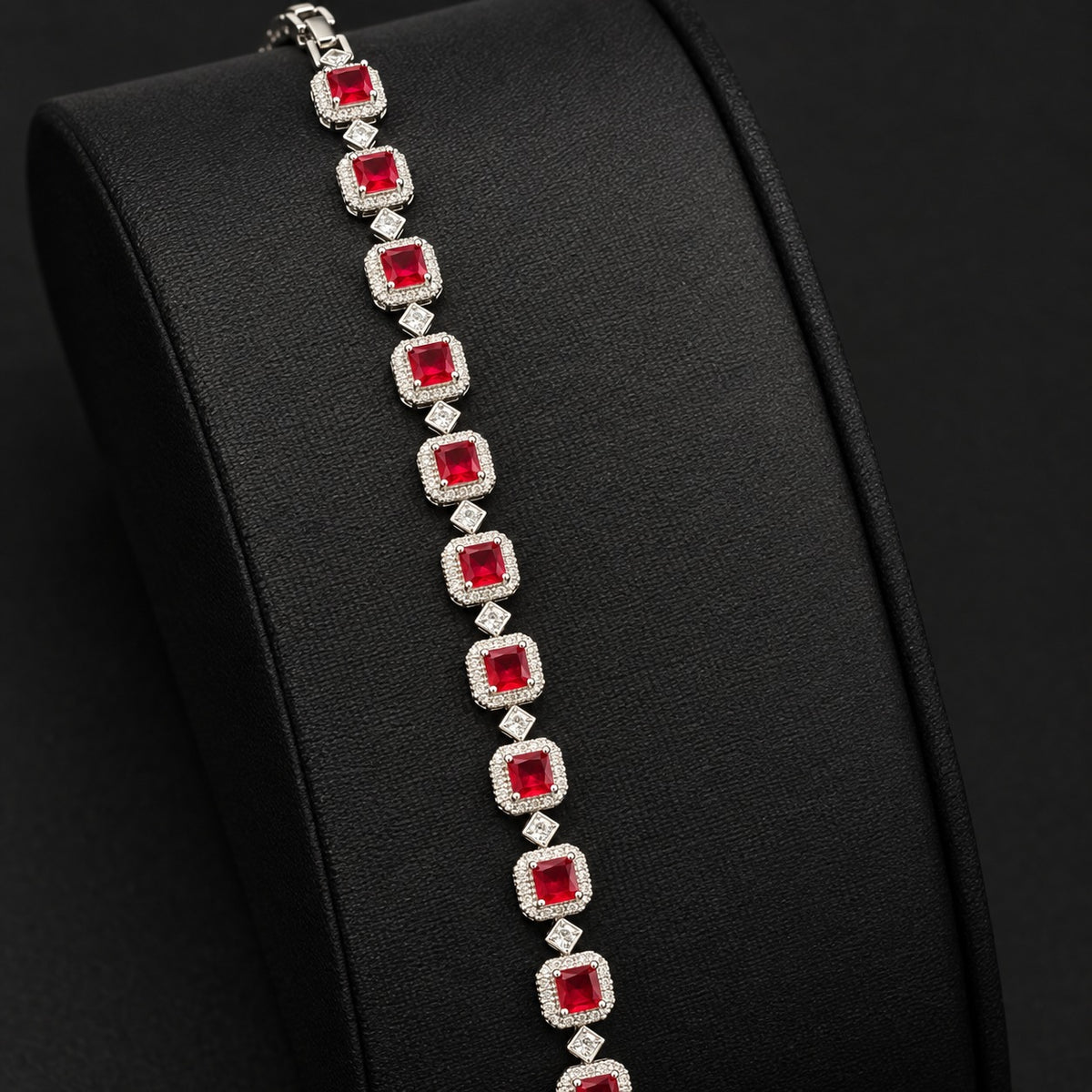 Silver-tone Regal Grid Bracelet featuring square-cut  red gemstones surrounded by clear zircon borders and connected with small diamond-shaped zircon links, available in ruby red, emerald green and clear zircon.