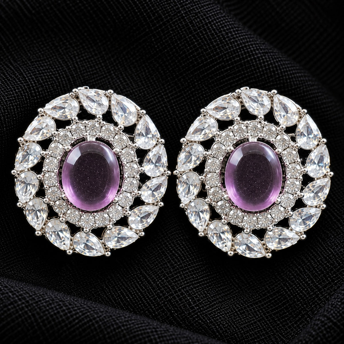 Detailed close-up of Regal Wreath Studs showing the purple oval centre stone, inner zircon border and outer ring of pear-cut clear stones.