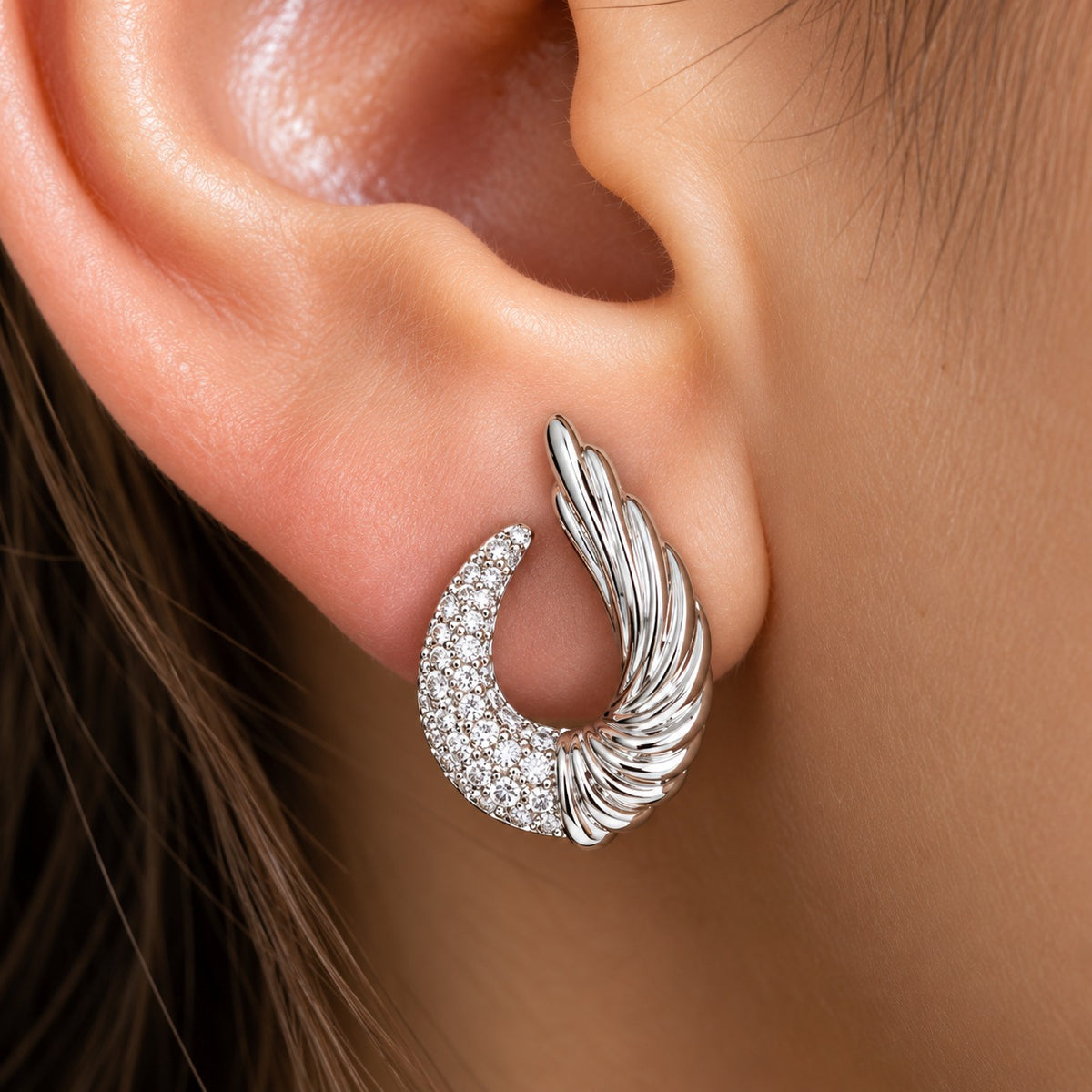Silver Celestial Wing Crescent Stud worn on the ear, showing the curved zircon crescent and upward sculpted wing design.