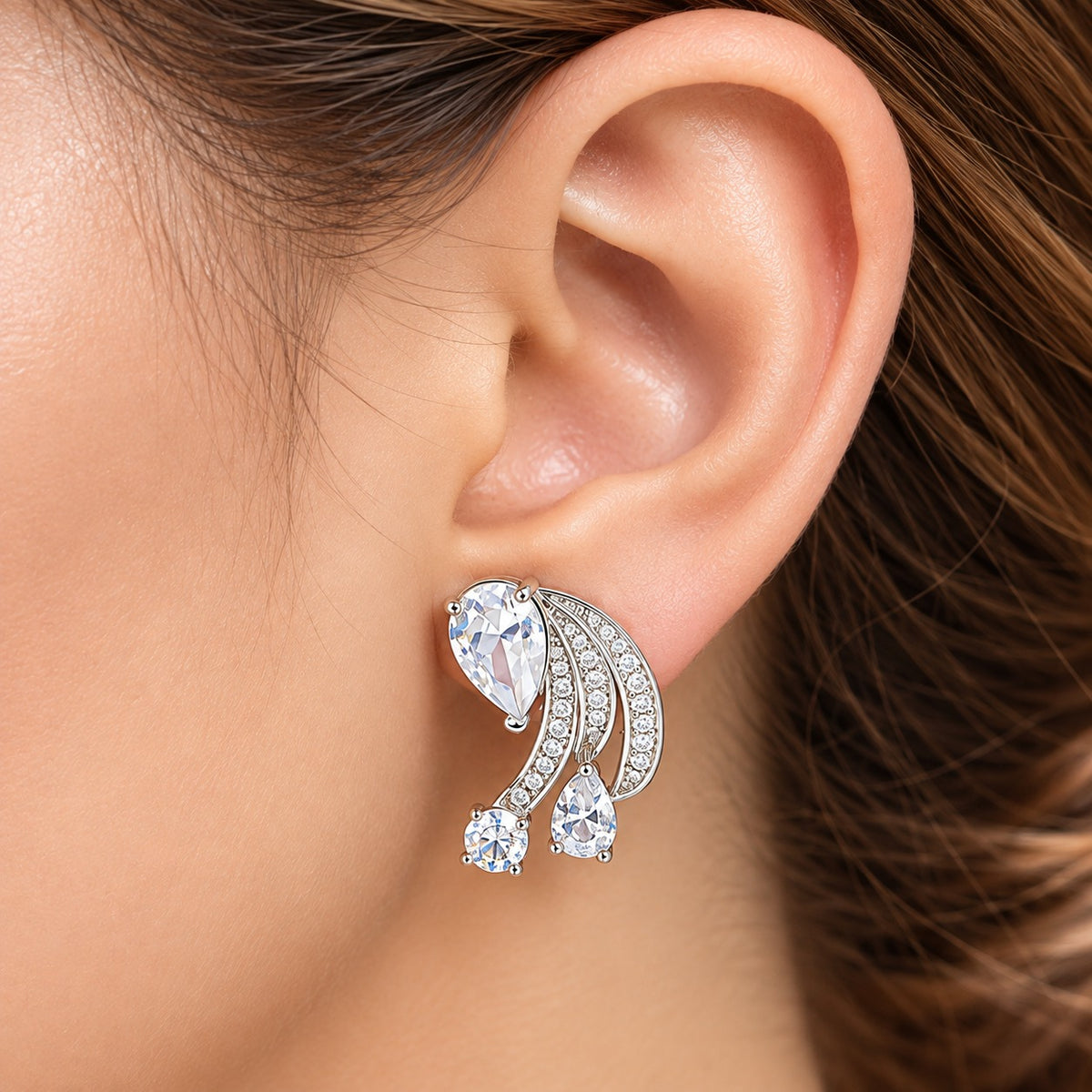 Angelique Wing Stud worn along the earlobe, showing its three curved zircon wings and cascading clear stones
