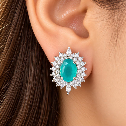 Model wearing The Duchess Oval Studs in aqua blue, featuring a large oval centre stone with an ornate clear zircon surround.