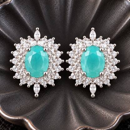 The Duchess Oval Studs featuring aqua blue oval centre stones surrounded by clear zircon accents in a silver-tone setting