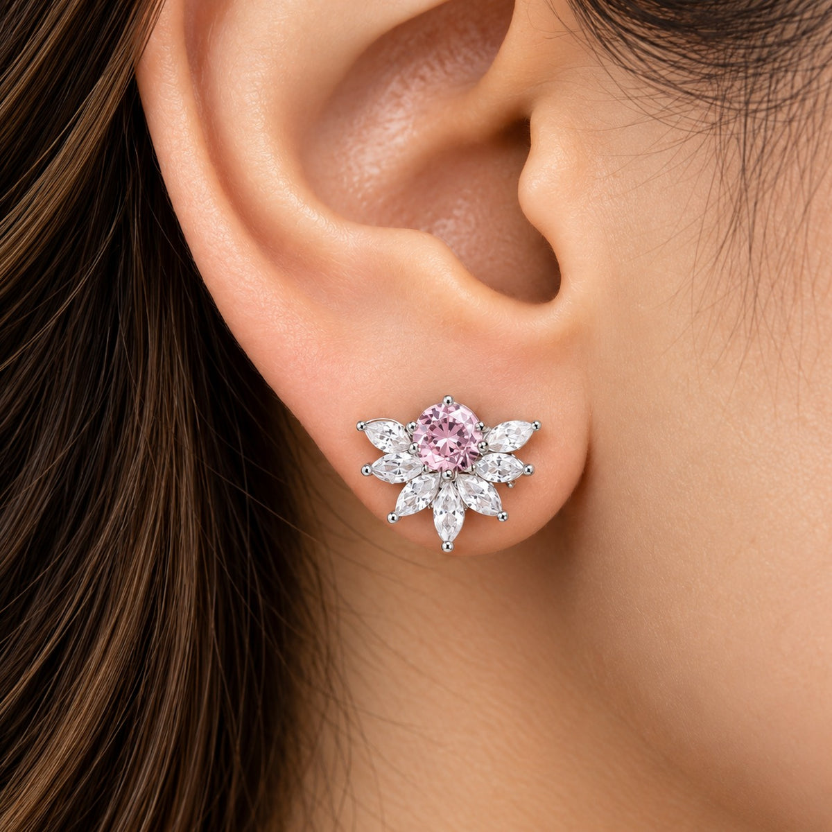 Model wearing Trillium Gem Petal Studs featuring a round pink centre stone surrounded by clear marquise zircon petals.