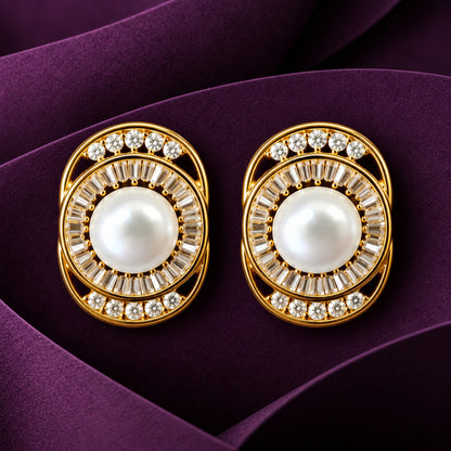 Close-up of oval gold-tone earrings featuring central white pearls surrounded by baguette-cut clear zircons.