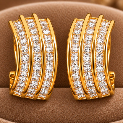 Close-up of Gilded Trio Arc Hoops showing three parallel gold curves with precisely arranged clear square-cut zircons.