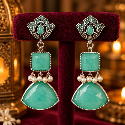 Heirloom Crest Drops in mint green with silver-toned detailing and pearl accents, displayed on rich burgundy velvet.