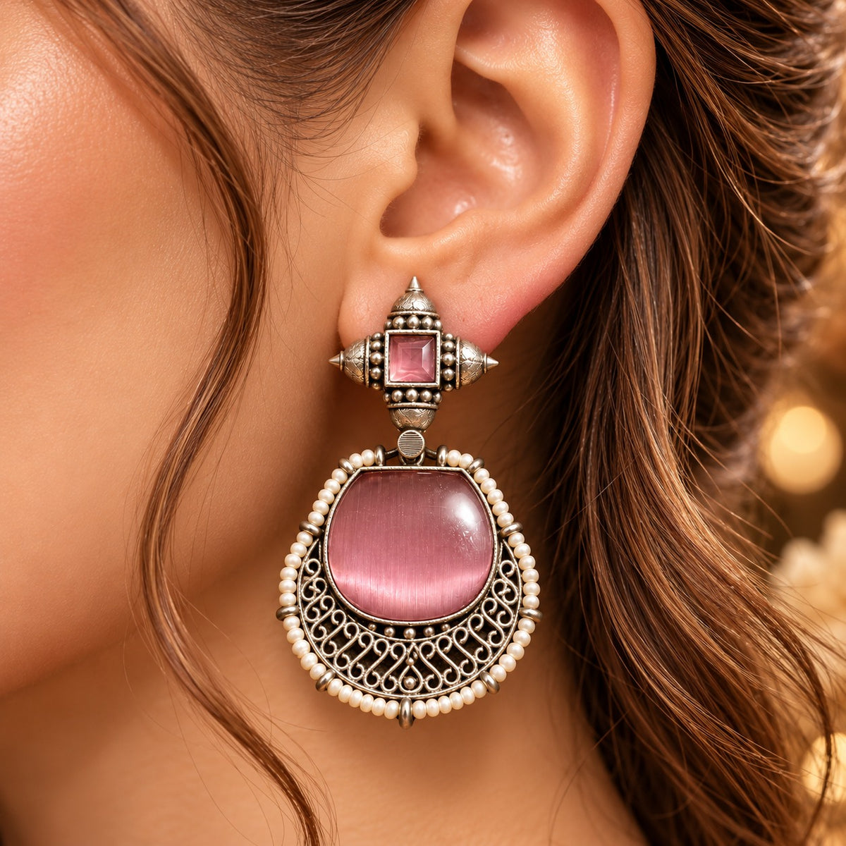  Close up of model wearing Heritage Rose Ancestral Crest earrings from The Legacy Collection.
