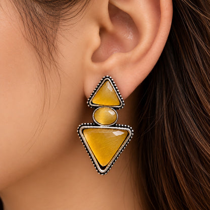  close up side profile of model wearing amber gold geometric statement earrings from The Legacy Collection.