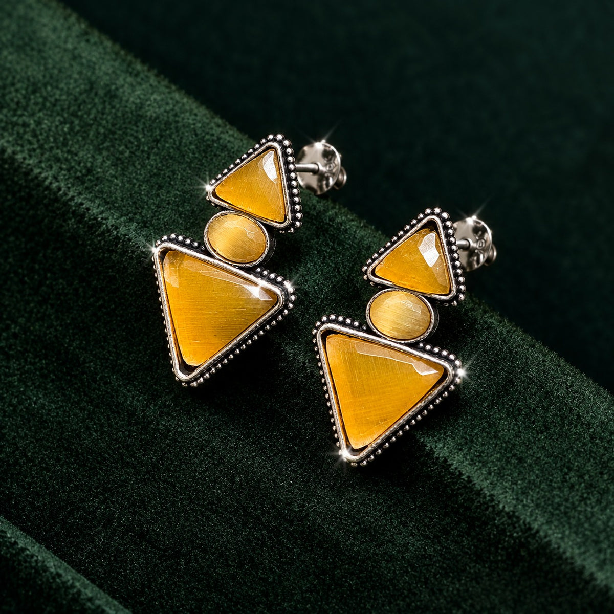 Amber gold Legacy Trine Earrings featuring two triangular stones, an oval centre and detailed silver-tone edging.