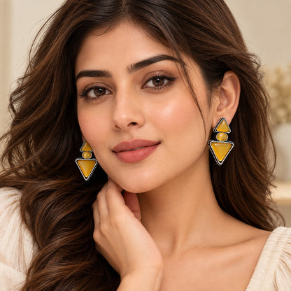 Model wearing amber gold geometric statement earrings from The Legacy Collection.