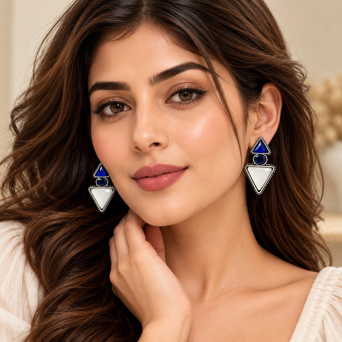 Model wearing sapphire blue and ivory geometric statement earrings from The Legacy Collection.