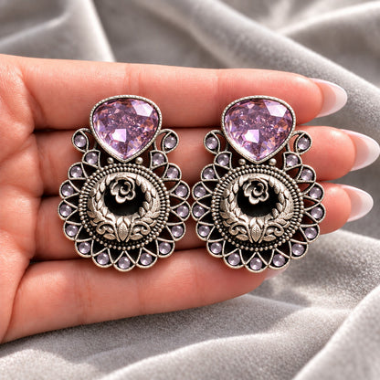 Soft Purple Courtyard Rose Earrings displayed on a hand, showing their statement size and intricate ornamental detailing.