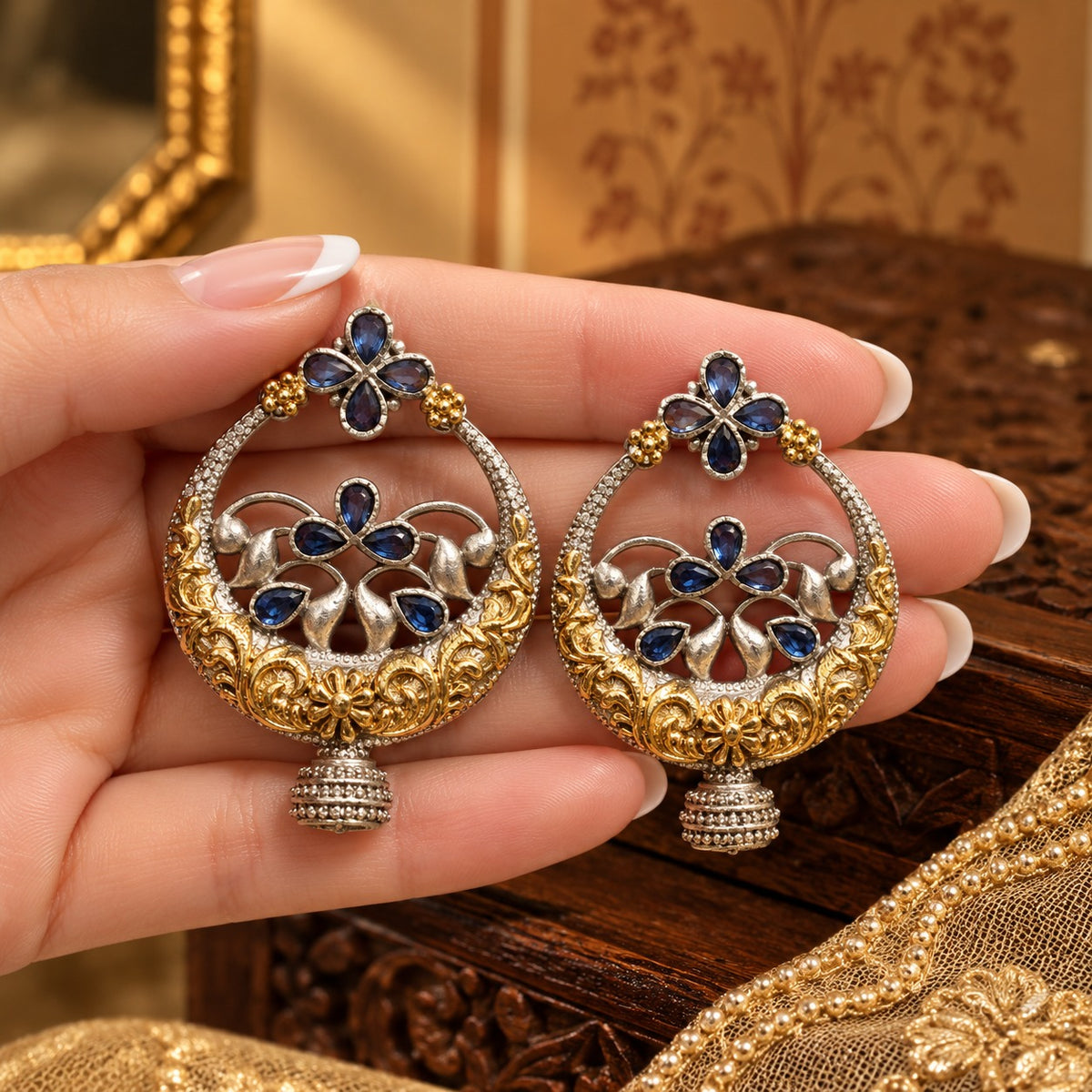 Hand-held view showing the statement size and detailed gold and silver-tone craftsmanship of the Azure Courtyard Earrings