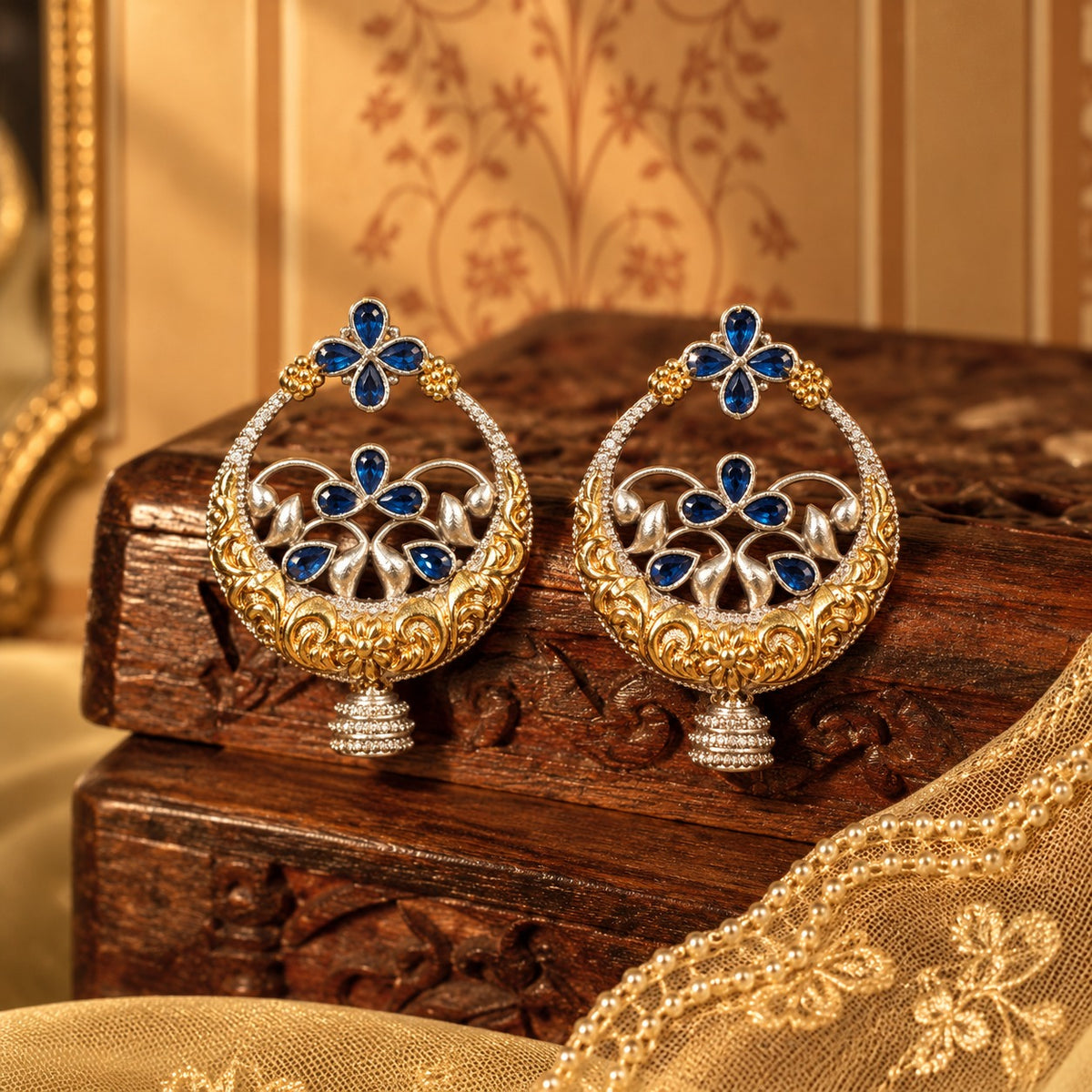 statement circular earrings with deep blue teardrop stones, sculpted floral metalwork and jhumka-style drops.
