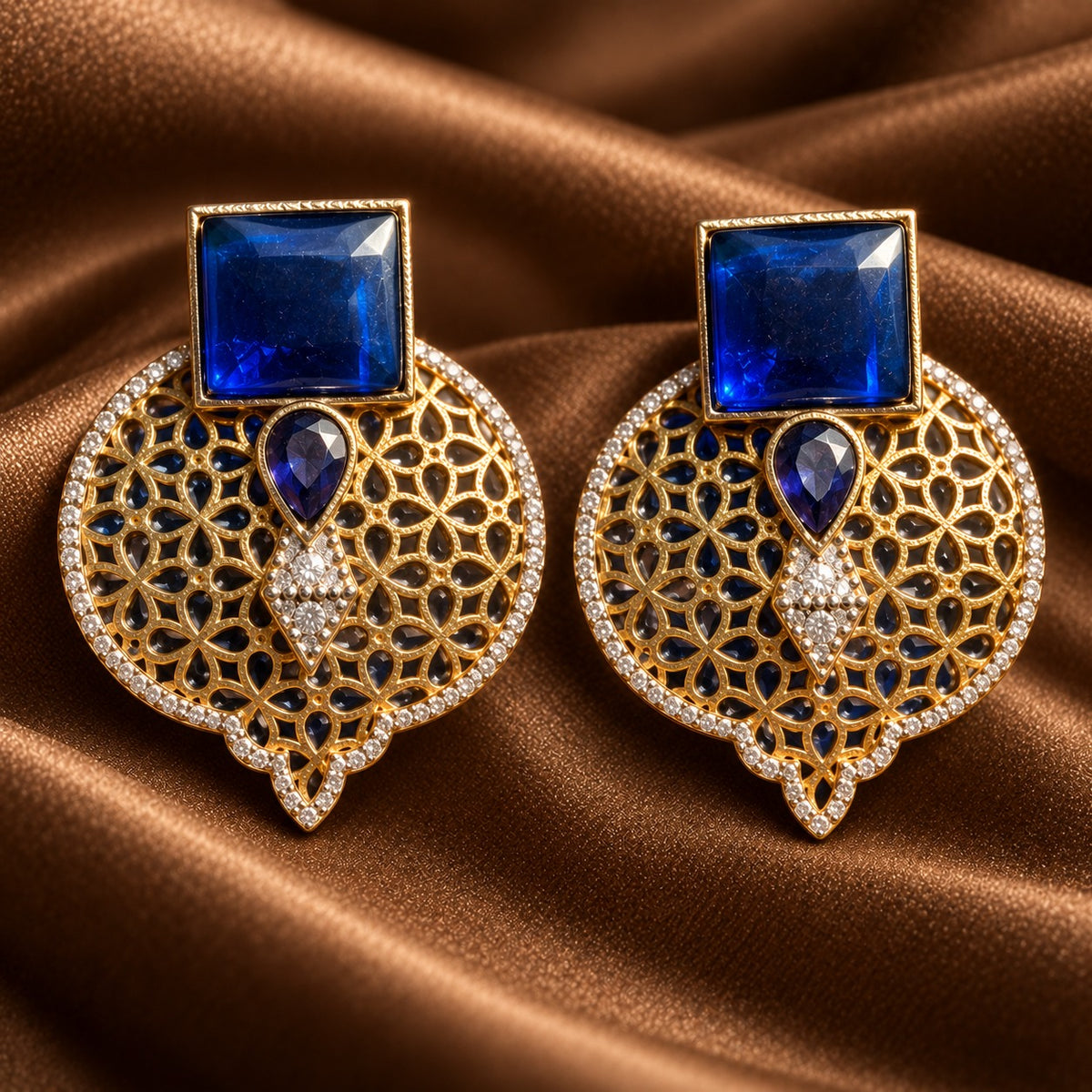 Sapphire blue Sovereign Court Earrings featuring contrasting geometric stones, ornate gold-tone detailing and a clear zircon-edged frame