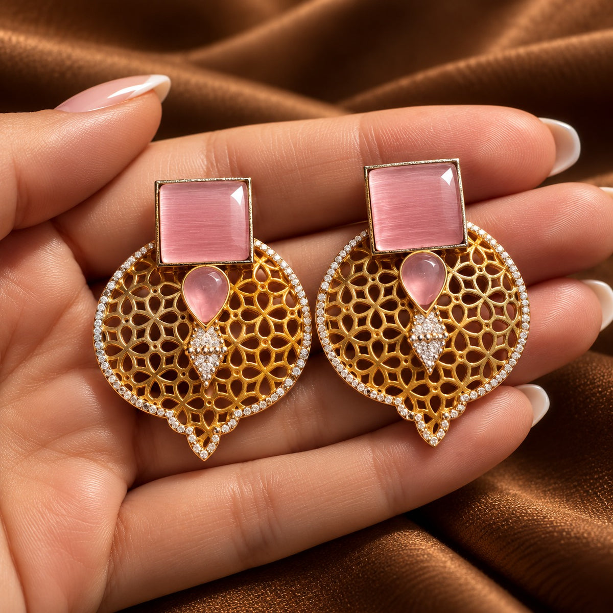 Hand-held close-up of Sovereign Court Earrings highlighting the geometric stones, detailed open latticework and clear zircon border.