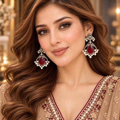 Model wearing The Royal Treasury Earrings, showing their statement drop silhouette, teardrop centre stone and intricate pearl-like detailing.