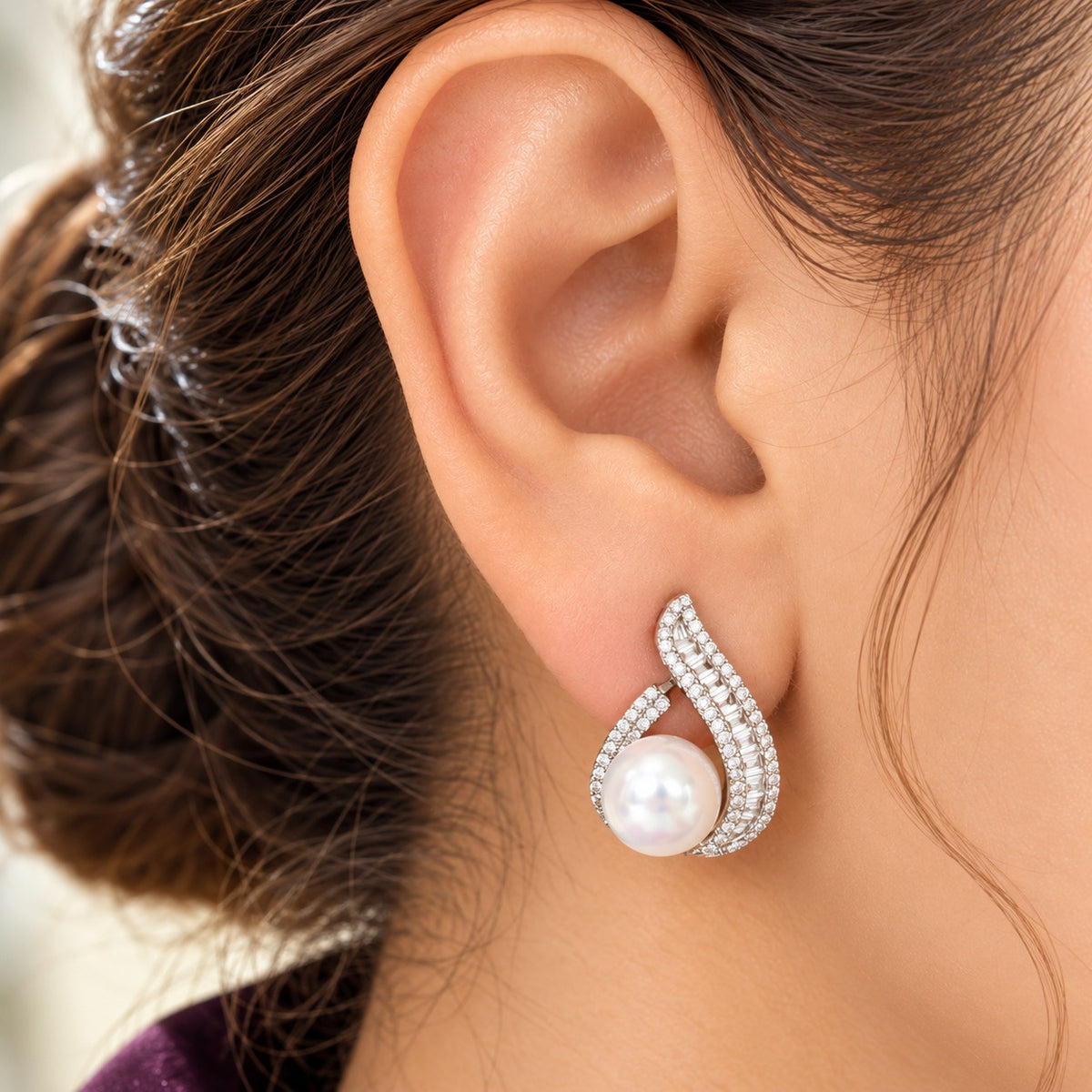 Model wearing The Pearl Plume Earrings with luminous pearls and zircon-set feather-inspired curves.