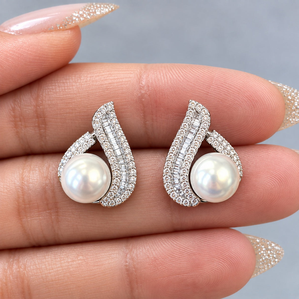 Pair of S925 Pearl Plume Earrings displayed on fingers, showing their size, pearl detail and intricate zircon setting