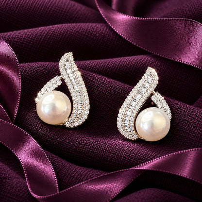 The Pearl Plume Earrings in S925 silver featuring luminous pearls and sweeping zircon-set curves on rich plum fabric.