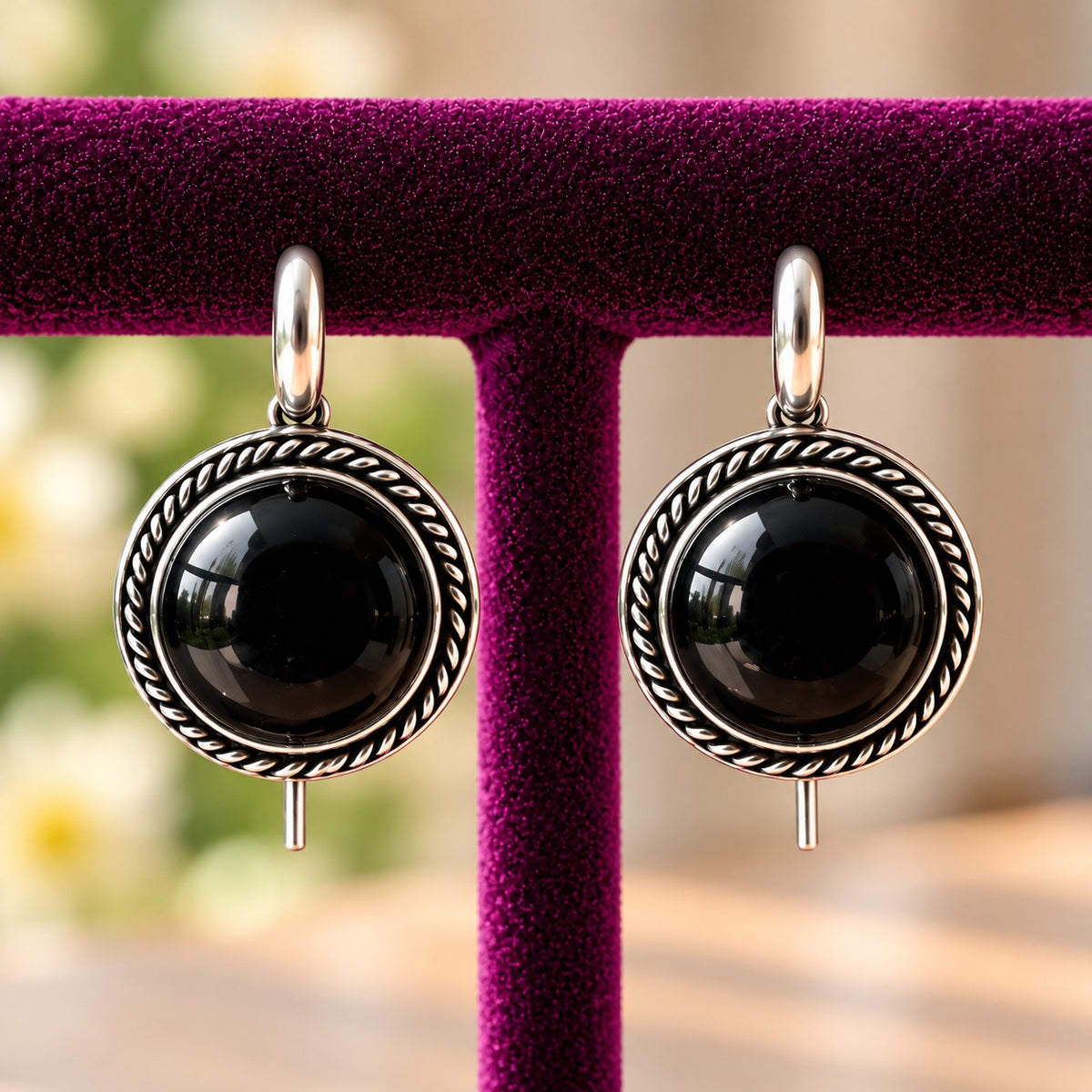 Regent Cabochon Earrings featuring glossy black domed stones surrounded by twisted antique silver-tone borders.
