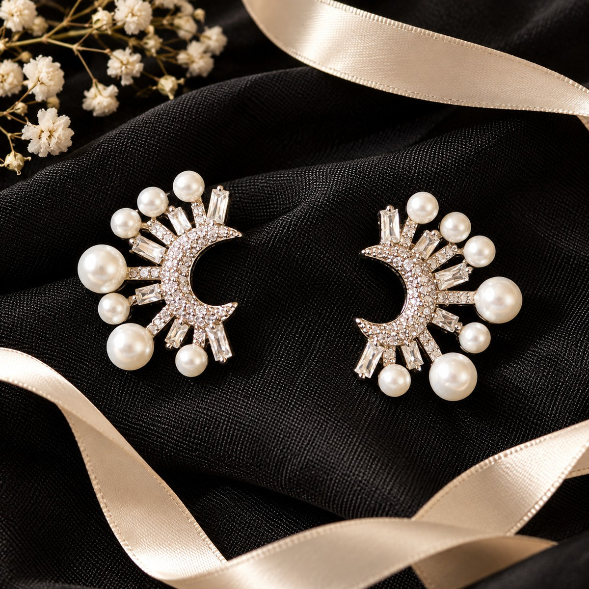 crescent-shaped earrings showcasing round zircon accents, rectangular baguette-cut stones and lustrous white faux pearls arranged in a radiating pattern.