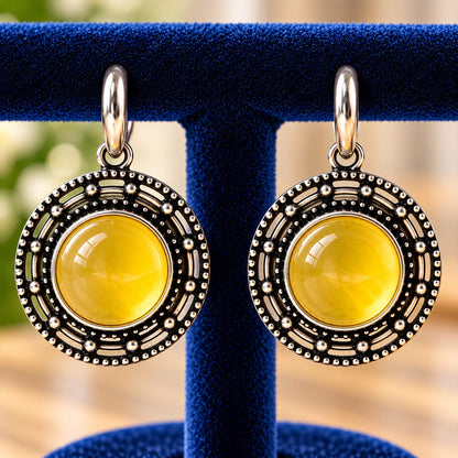 Solstice Medallion Earrings featuring a glossy lime-yellow cabochon centre, antique oxidised silver-tone finish and intricate circular beadwork.