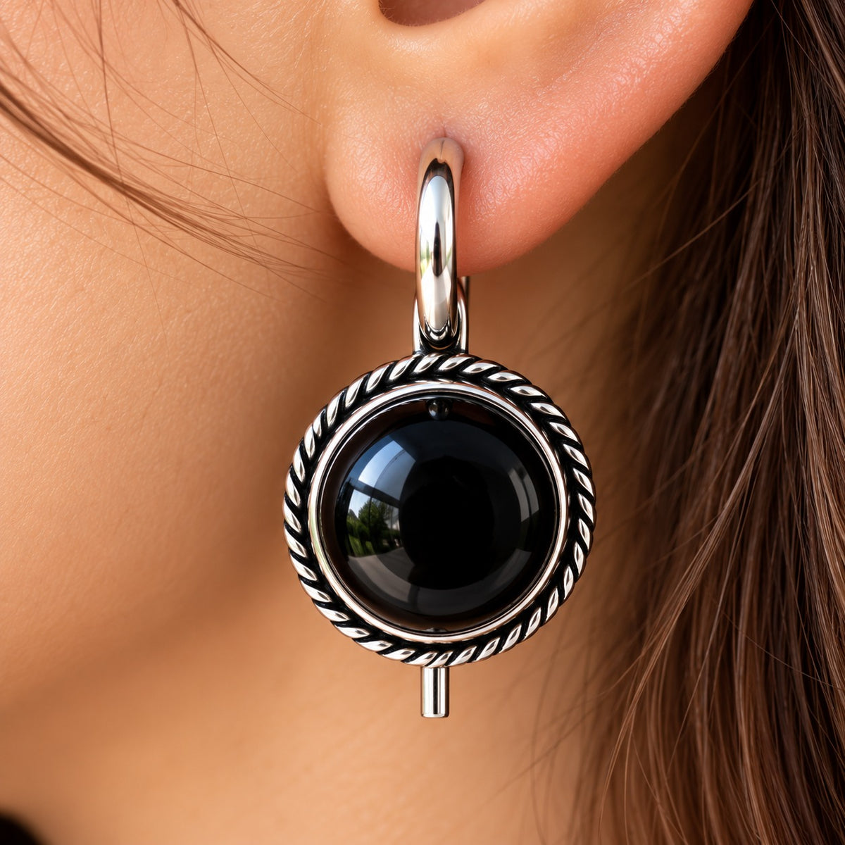 Model wearing Regent Cabochon Earrings, showcasing the round domed centre, vintage-inspired twisted border and polished silver-tone hoop.