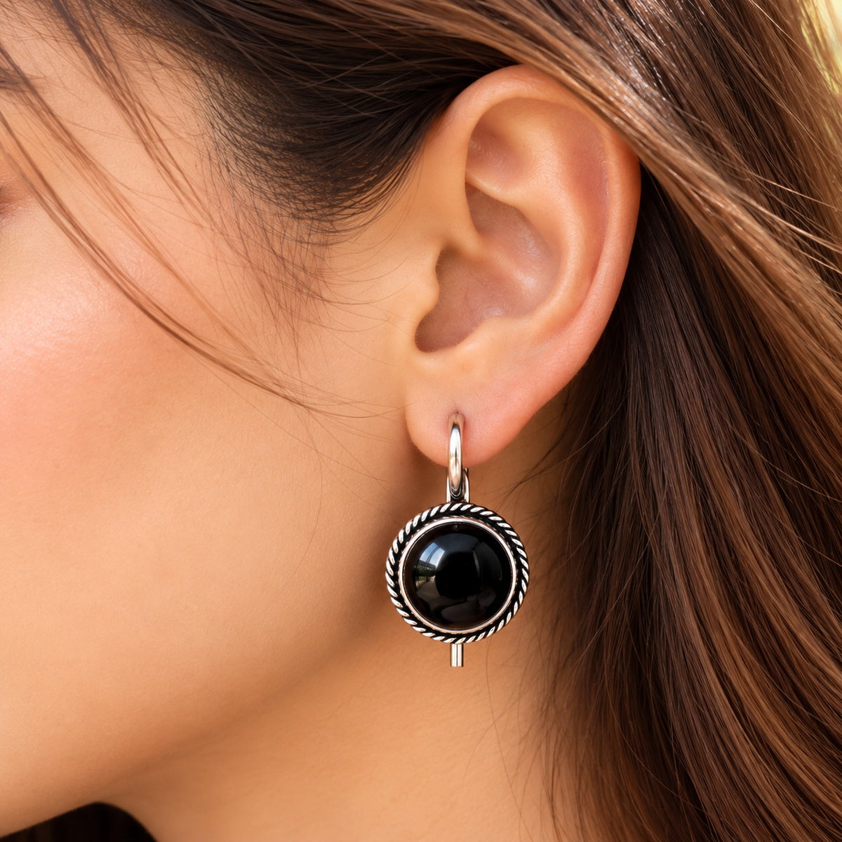 Model wearing Regent Cabochon Earrings, showcasing the round domed centre, vintage-inspired twisted border and polished silver-tone hoop.