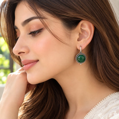 Model wearing Regent Cabochon Earrings, showcasing the round domed centre, vintage-inspired twisted border and polished silver-tone hoop.