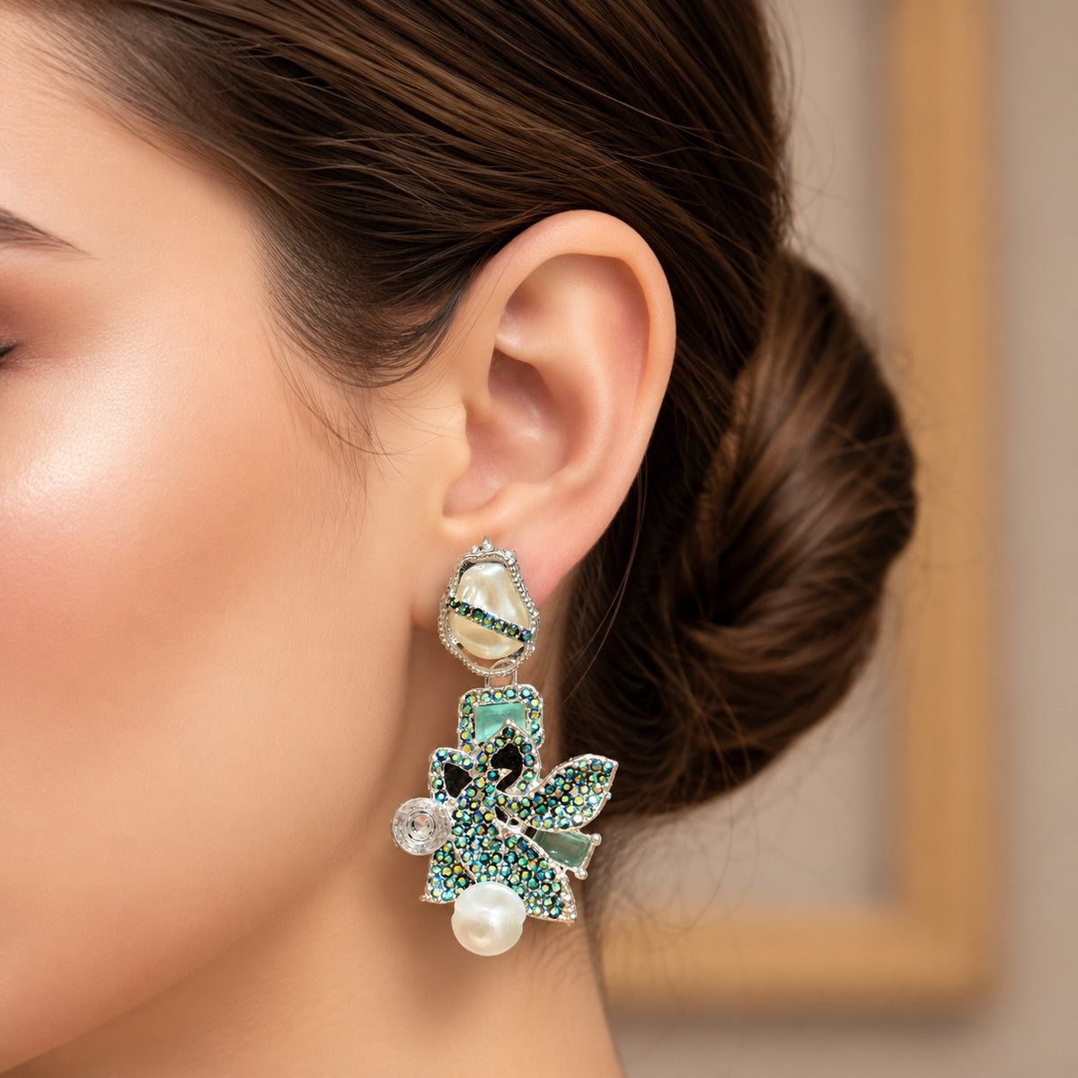 Model wearing Baroque Mosaic statement earrings with intricate  teal crystal embellishments and pearl accents.