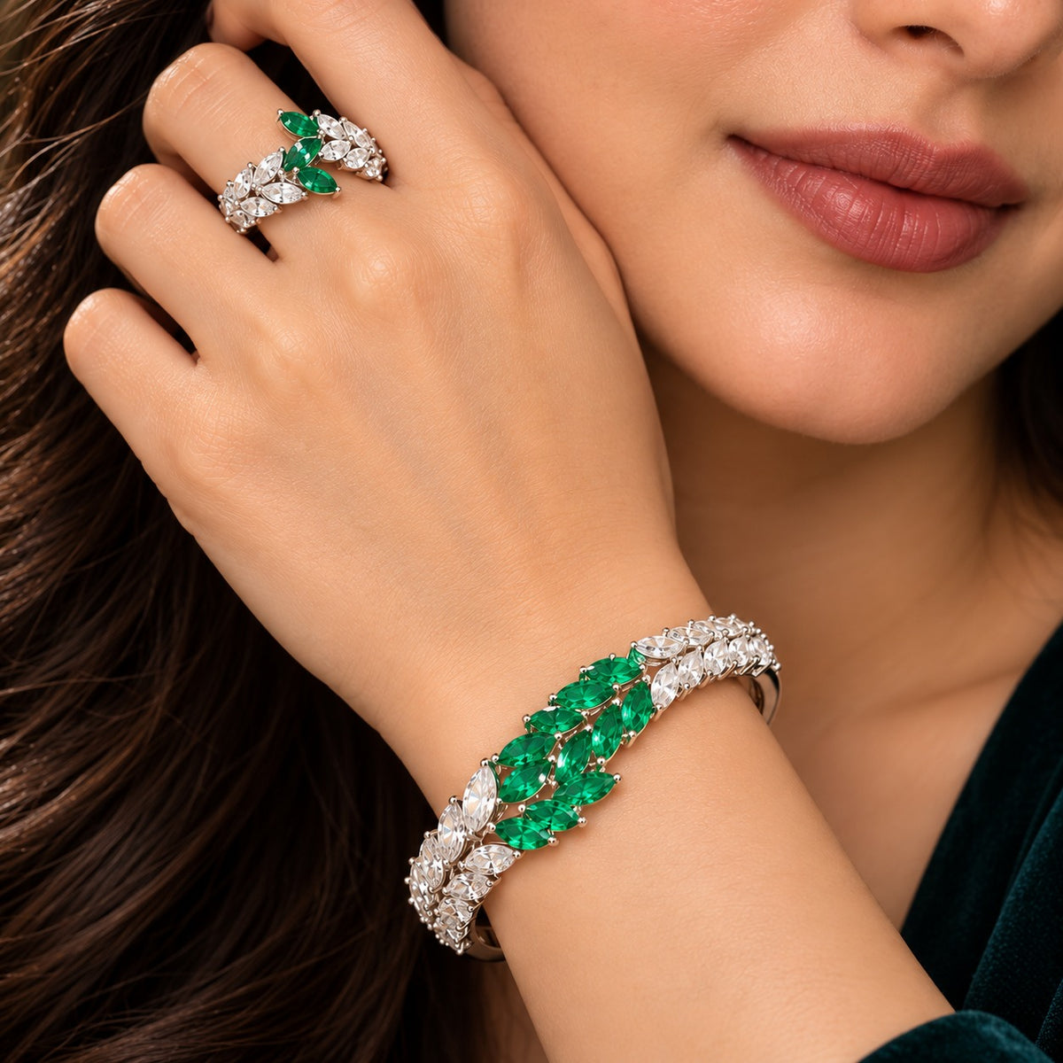 Woman wearing the Emerald Laurel Zircon Bracelet and matching ring with marquise-cut green and clear stones.