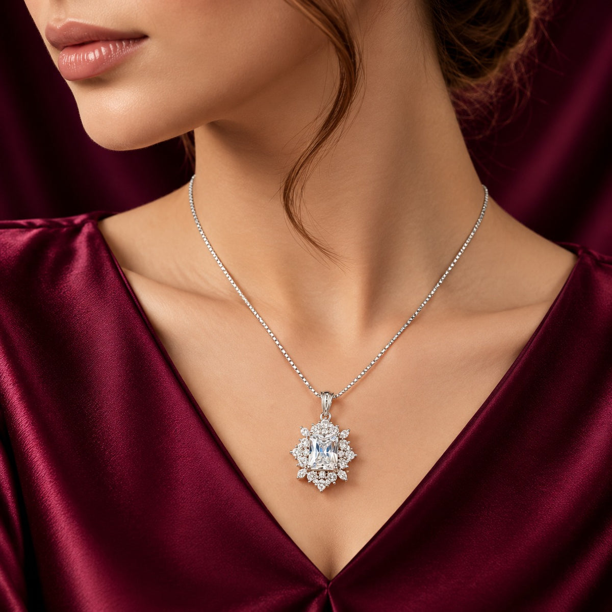 Model wearing the Regent Radiance Zircon Pendant on a delicate silver-tone chain, styled with a deep burgundy satin outfit, highlighting its ornate design and brilliant clear zircon stones.