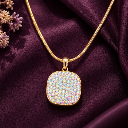 Detailed close-up of a rounded-square gold-tone pendant with densely arranged iridescent zircon stones in soft pink, lavender, blue and champagne hues.