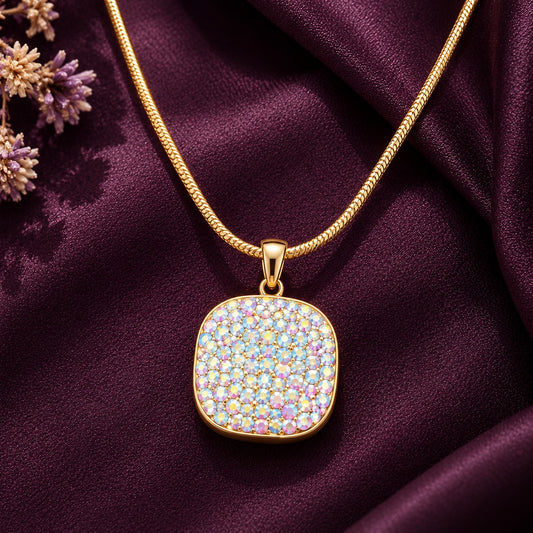 Detailed close-up of a rounded-square gold-tone pendant with densely arranged iridescent zircon stones in soft pink, lavender, blue and champagne hues.